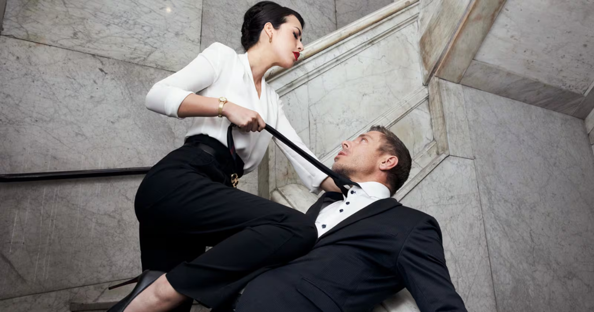 Mulher vestindo blusa branca de mana comprida, puxando um homem pela gravata